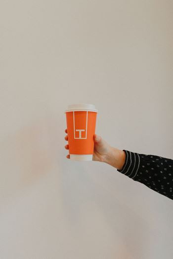 a hand holding a disposable cup of coffee  at Livano Norfolk, Norfolk, Virginia